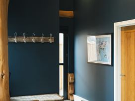 An entrance hall with a bench and coat hooks at The Farmhouse in Addingham
