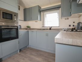 A kitchen with cabinets and appliances at No. 4 Fistral in Newquay