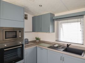 A kitchen with cabinets and appliances at No. 4 Fistral in Newquay