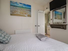 A bedroom with a bed and television at No. 4 Fistral in Newquay