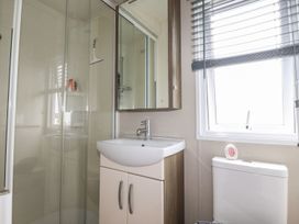 A bathroom with a shower, sink, and toilet at No. 4 Fistral in Newquay