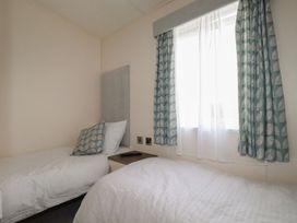 A bedroom with two beds and a window at No. 4 Fistral in Newquay