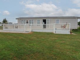 A mobile home with a deck and grass area at No. 4 Fistral in Newquay
