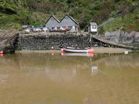 A boat near a stone building and pier at No. 4 Fistral Newquay