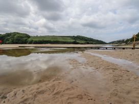A beach with water and a wooden pier at No. 4 Fistral in Newquay