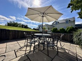 A patio with a table, chairs, and an umbrella at Seeview, Charleville