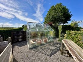 A greenhouse and flower pots in a garden at Seeview in Charleville