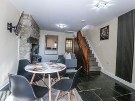 A living room with a stone wall and stairs at Tegfan in Garndolbenmaen near Porthmadog