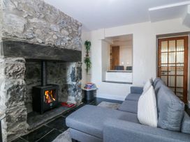 A sitting room with a fireplace and sofa at Tegfan in Garndolbenmaen near Porthmadog