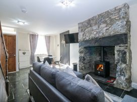 A living room with a sofa and fireplace at Tegfan in Garndolbenmaen near Porthmadog