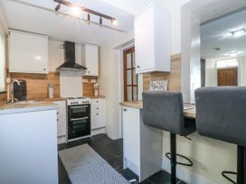 A kitchen with cabinets and bar stools at Tegfan in Garndolbenmaen near Porthmadog