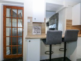 A kitchen with stools and a sign at Tegfan in Garndolbenmaen near Porthmadog