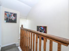 A hallway with a staircase and artworks on the wall at Tegfan in Garndolbenmaen near Porthmadog