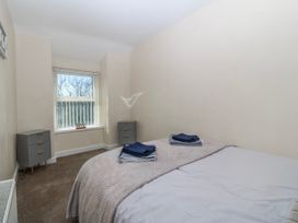 A bedroom with a bed and nightstands at Tegfan in Garndolbenmaen near Porthmadog