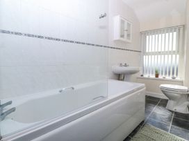 A bathroom with a bathtub, sink, and toilet at Tegfan in Garndolbenmaen near Porthmadog