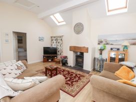 A living room with a fireplace and television at Swallow Cottage in Llangefni