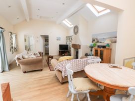 A living room with a sofa and dining table at Swallow Cottage in Llangefni