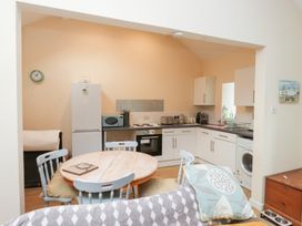 A kitchen with appliances and dining area at Swallow Cottage in Llangefni