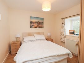 A bedroom with a bed and nightstand at Swallow Cottage in Llangefni