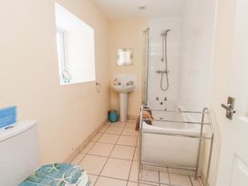 A bathroom with a bathtub, sink, and toilet at Swallow Cottage in Llangefni