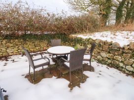 An outdoor seating area with a table and chairs at Swallow Cottage in Llangefni