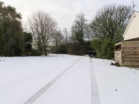 An outdoor area with snow and tire tracks at Swallow Cottage in Llangefni