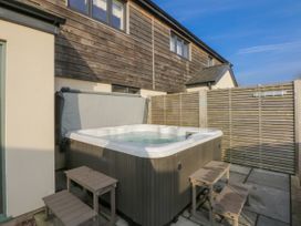 An outdoor area with a hot tub and wooden steps at Bell House in Llanfechell