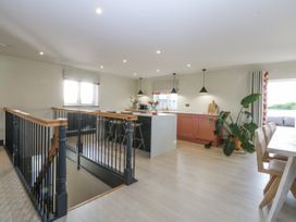 A kitchen with an island and dining area at Bell House in Llanfechell