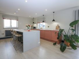 A kitchen with a kitchen island and bar stools at Bell House in Llanfechell