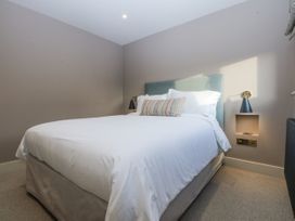 A bedroom with a bed and bedside lamp at Bell House in Llanfechell