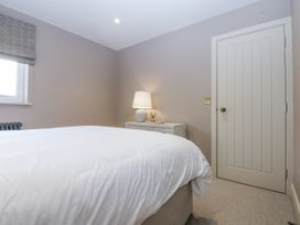 A bedroom with a bed and lamp at Bell House in Llanfechell