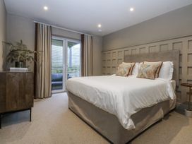 A bedroom with a bed and a sliding door at Bell House in Llanfechell