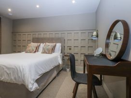 A bedroom with a bed, desk, and chair at Bell House in Llanfechell