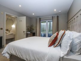 A bedroom with a bed and a view of the garden at Bell House in Llanfechell