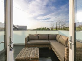 A balcony with a sofa and table at Bell House in Llanfechell