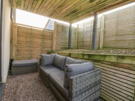 A seating area with a sofa and fence at Bell House in Llanfechell