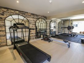 A gym with exercise equipment including a treadmill and weights at Bell House Llanfechell