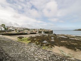 A coastal scene with boats and a pier at Bell House in Llanfechell