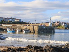 Boats at a pier with houses in the background at Bell House Llanfechell
