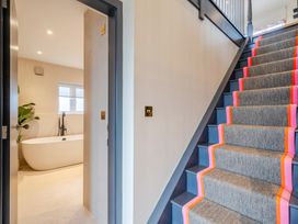 A hallway with a staircase and a bathtub visible at Bell House in Llanfechell