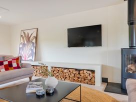 A living room with a television and a fireplace at Bell House in Llanfechell
