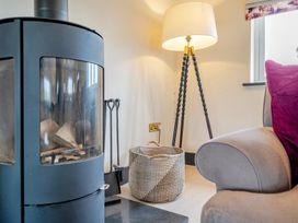 A living room with a fireplace and lamp at Bell House in Llanfechell
