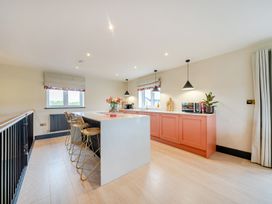 A kitchen with an island and stools at Bell House in Llanfechell