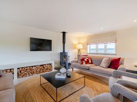 A living room with a television and fireplace at Bell House in Llanfechell