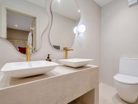 A bathroom with two sinks and a toilet at Bell House Llanfechell