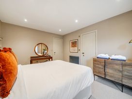 A bedroom with a bed and dresser at Bell House in Llanfechell