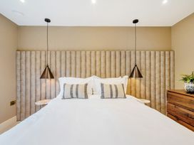 A bedroom with a bed and decorative headboard at Bell House in Llanfechell