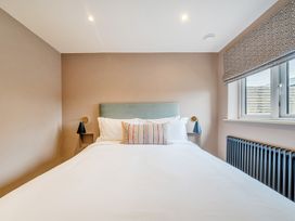 A bedroom with a bed and wall lamp at Bell House in Llanfechell