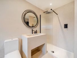 A bathroom with a shower, washbasin, and toilet at Bell House in Llanfechell