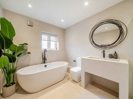 A bathroom with a bathtub, toilet, and sink at Bell House in Llanfechell